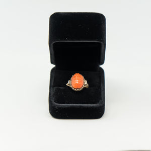 an orange ring in a black velvet box